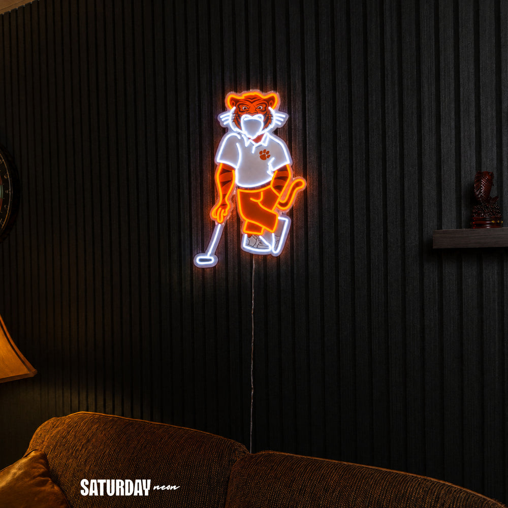 Clemson Tigers Swinging Tiger Golf Mascot LED Neon Sign - 17.54" x 24" above a couch - Saturday Neon