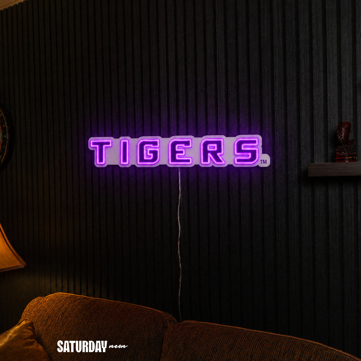 LSU Tigers Wordmark LED Neon Sign - 24" x 3.4" above a couch - Saturday Neon