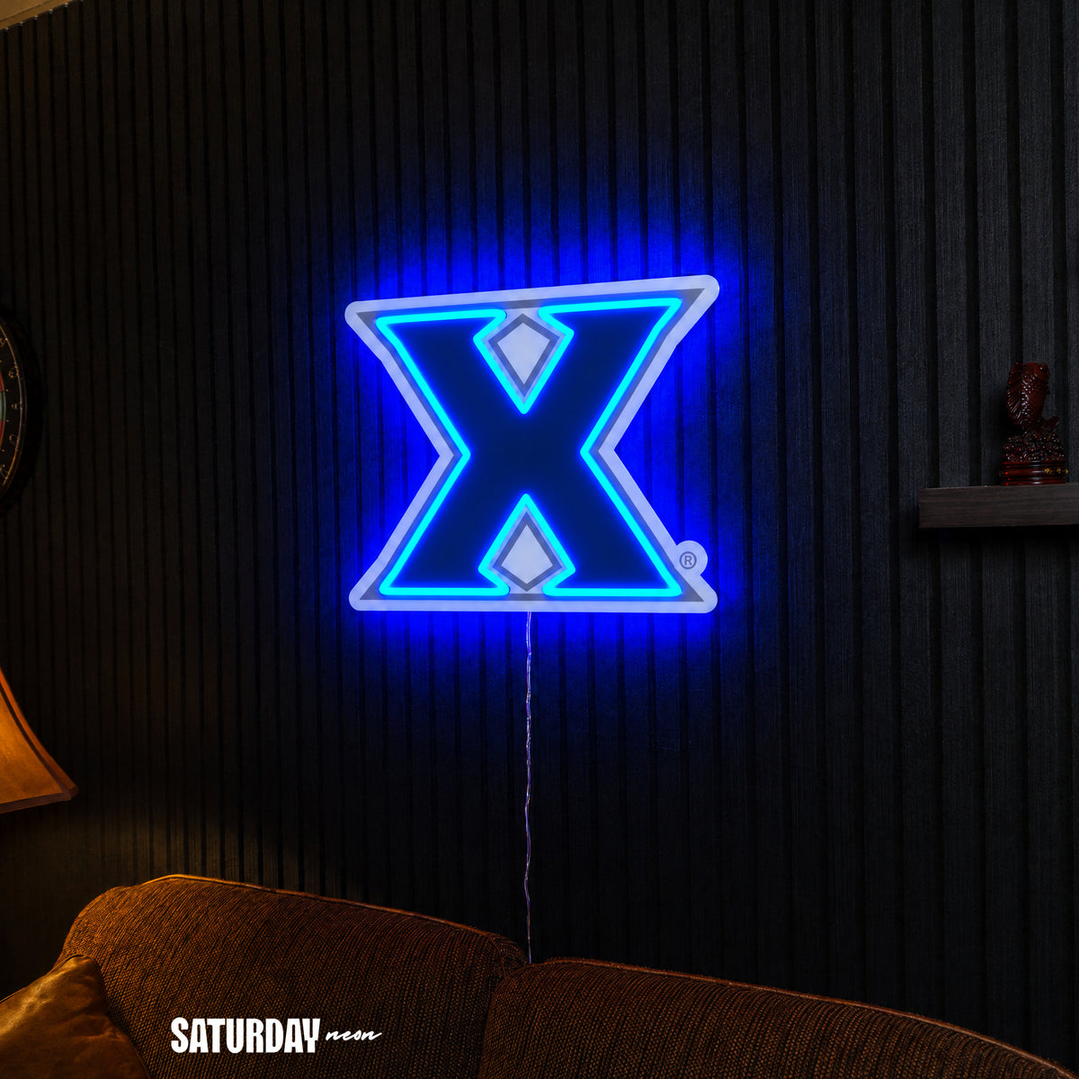 Xavier Musketeers X Primary Mark LED Neon Sign - Plus (24" x 19.42") above a couch - Saturday Neon