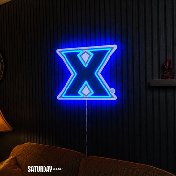 Xavier Musketeers X Primary Mark LED Neon Sign - Plus (24" x 19.42") above a couch - Saturday Neon