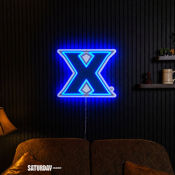 Xavier Musketeers X Primary Mark LED Neon Sign - Plus (24" x 19.42") in a living room - Saturday Neon